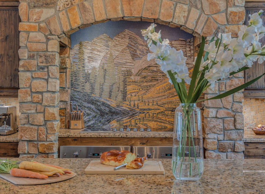 Experience luxury in this gourmet kitchen, featuring a stunning mosaic backsplash and a professional-grade espresso machine.