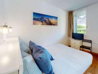 This cozy bedroom features a comfortable bed adorned with plush blue pillows, perfect for a restful night's sleep.