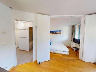 Discover this charming studio apartment featuring a comfortable bed and a modern bathroom, perfect for a relaxing getaway.