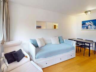 This inviting living space features a comfortable daybed with blue bedding and decorative pillows, perfect for relaxation.