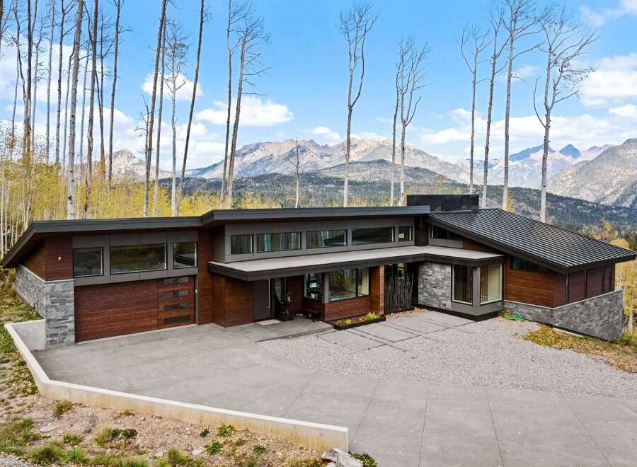 Experience modern luxury in this stunning mountain home, featuring a striking architectural design with rich wood and stone accents.