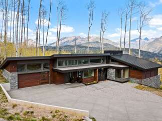 Experience modern luxury in this stunning mountain home, featuring a striking architectural design with rich wood and stone accents.