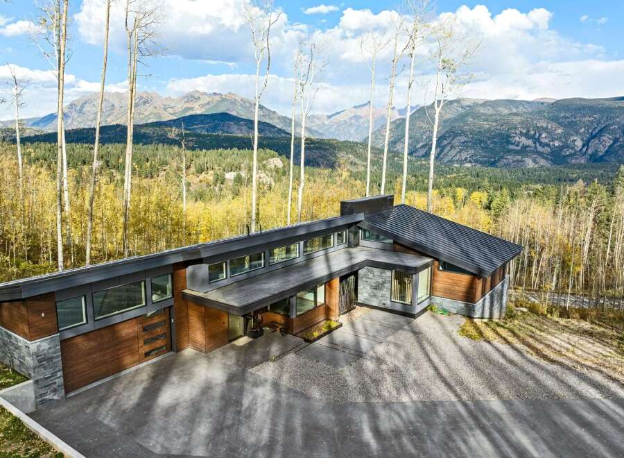 Experience modern luxury in this stunning mountain home, featuring a striking architectural design with natural wood and stone accents.