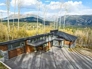 Experience modern luxury in this stunning mountain home, featuring a striking architectural design with natural wood and stone accents.