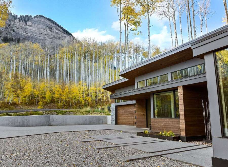 Experience modern luxury nestled amidst the vibrant autumn foliage and majestic mountain backdrop.