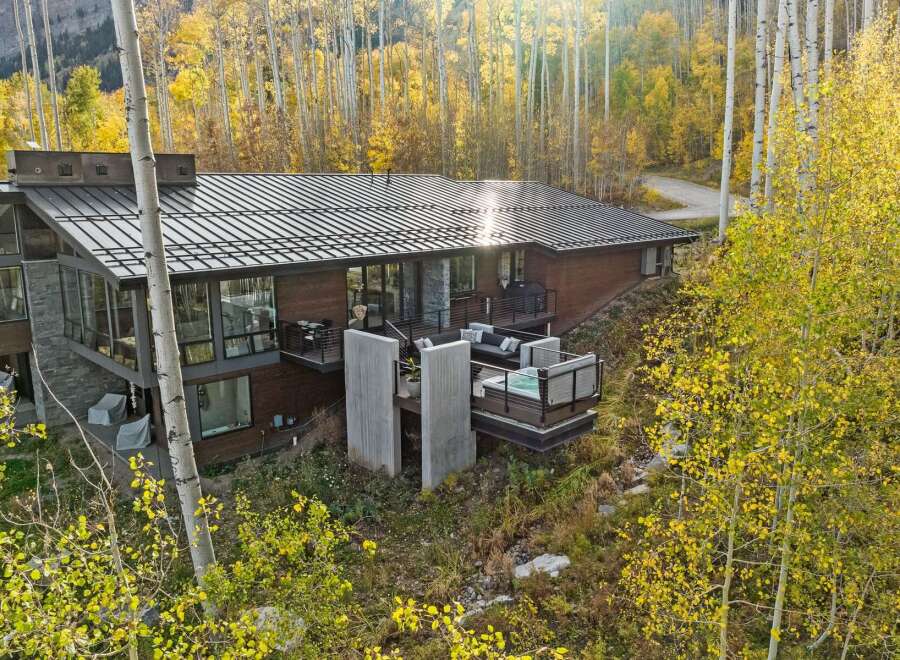 Experience luxury mountain living in this stunning modern home, nestled amidst vibrant autumn foliage.