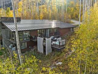 Experience luxury mountain living in this stunning modern home, nestled amidst vibrant autumn foliage.