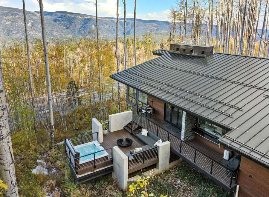 Experience luxury mountain living in this stunning modern home, featuring a private hot tub on the deck with breathtaking forest and mountain views.