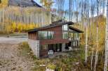 Nestled amidst a vibrant autumn aspen grove, this modern mountain home offers breathtaking views and a seamless indoor-outdoor living experience.