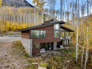 Nestled amidst a vibrant autumn aspen grove, this modern mountain home offers breathtaking views and a seamless indoor-outdoor living experience.