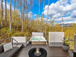 Experience ultimate relaxation on this stunning deck, featuring a luxurious hot tub and a modern fire pit, perfect for enjoying the crisp mountain air.