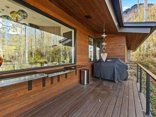 Enjoy outdoor living with this spacious deck featuring a built-in bar and a Weber grill, perfect for entertaining.
