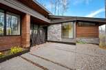 Experience modern luxury in this stunning home featuring a striking facade of warm wood and sleek stone.