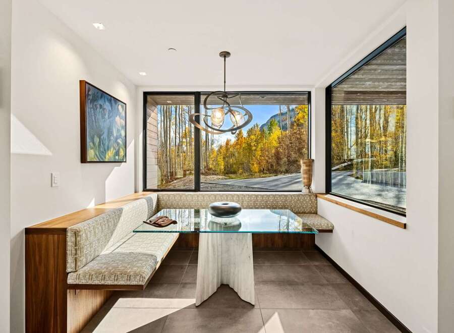 Experience breathtaking mountain views from this elegant dining nook, featuring a custom built-in banquette with plush seating.