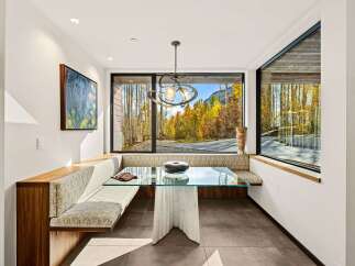 Experience breathtaking mountain views from this elegant dining nook, featuring a custom built-in banquette with plush seating.