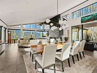 Experience luxury mountain living in this stunning contemporary home, featuring expansive windows that frame breathtaking panoramic views of the surrounding landscape.