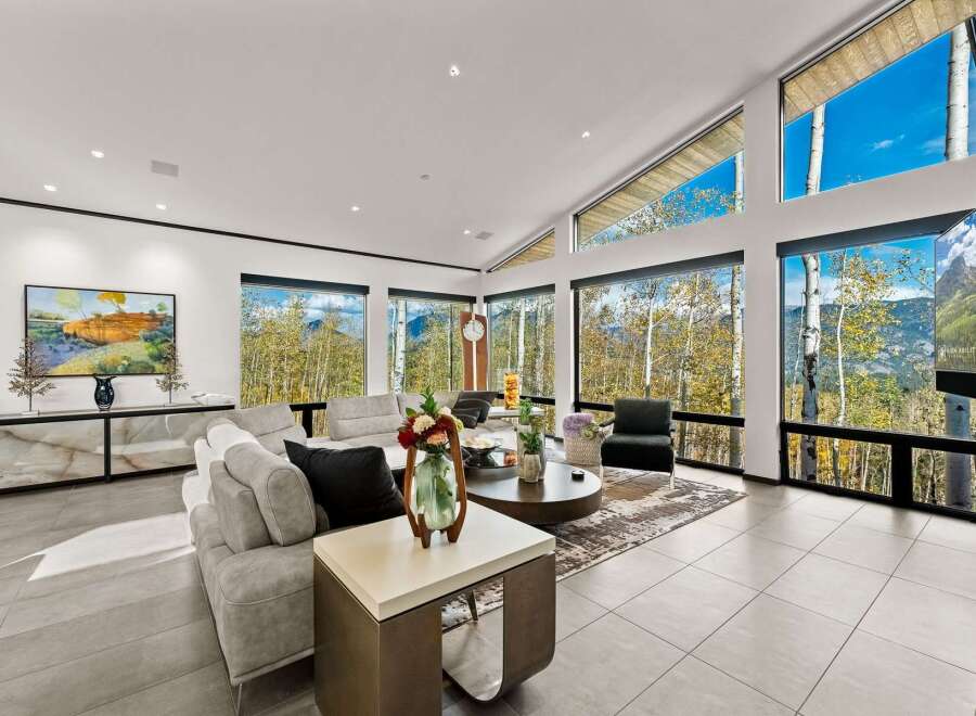 Experience breathtaking mountain views from this stunning living room, featuring a modern sectional sofa and a large coffee table perfect for gatherings.