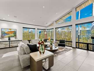 Experience breathtaking mountain views from this stunning living room, featuring a modern sectional sofa and a large coffee table perfect for gatherings.