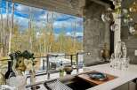 Experience luxury living with this stunning kitchen featuring a sleek countertop and modern fixtures, overlooking a breathtaking mountain landscape.