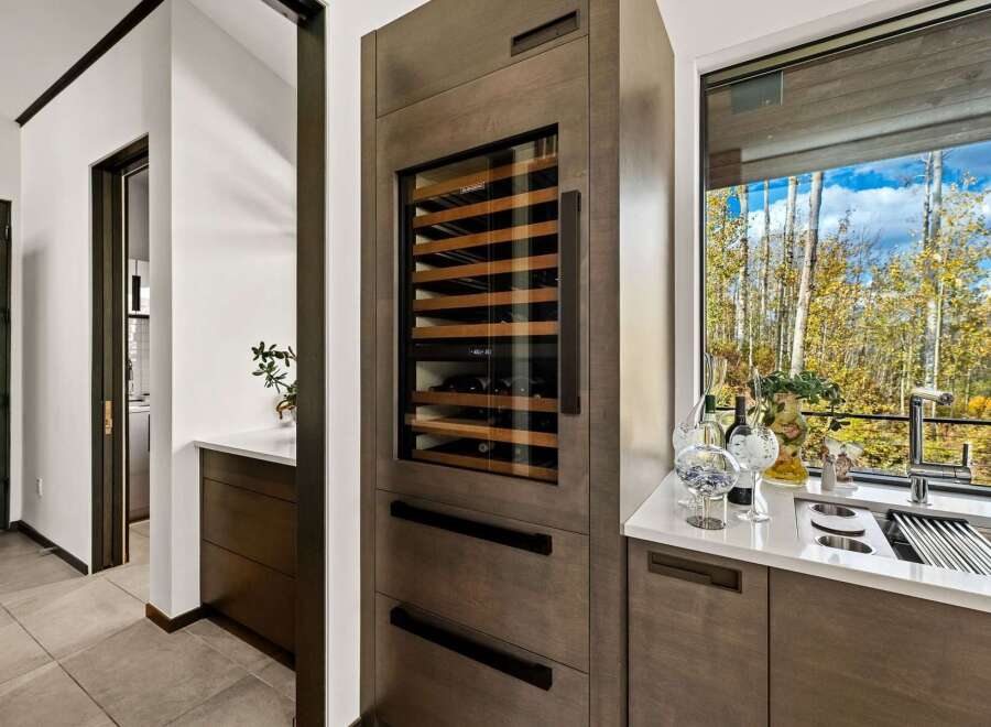 Experience luxury living with this stunning wine cellar, seamlessly integrated into a modern kitchen space.