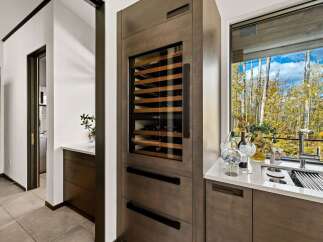 Experience luxury living with this stunning wine cellar, seamlessly integrated into a modern kitchen space.