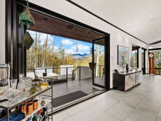 Experience breathtaking mountain views from this stunning modern home, featuring expansive glass doors that open to a spacious deck perfect for entertaining.