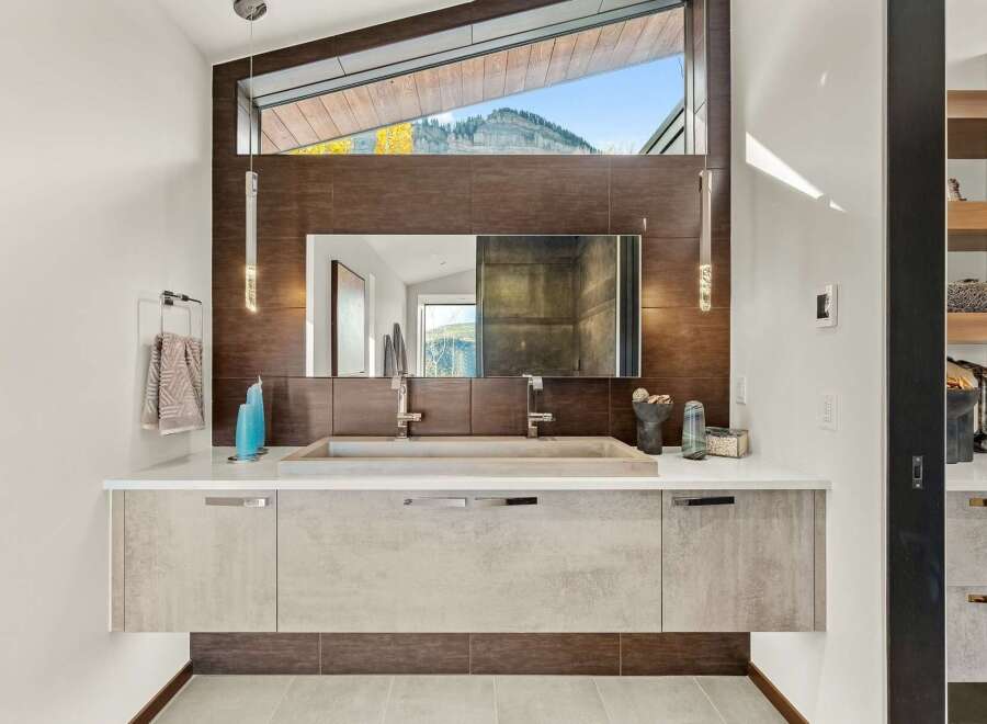 Experience luxury in this modern bathroom featuring a floating vanity with a sleek concrete sink and dual faucets.