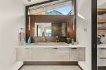 Experience luxury in this modern bathroom featuring a floating vanity with a sleek concrete sink and dual faucets.