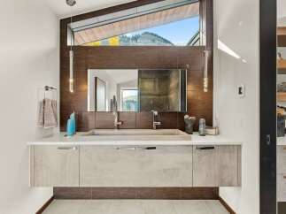 Experience luxury in this modern bathroom featuring a floating vanity with a sleek concrete sink and dual faucets.
