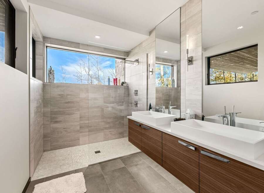 Experience modern luxury in this stunning bathroom featuring a spacious walk-in shower with a panoramic window offering breathtaking views.