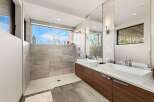 Experience modern luxury in this stunning bathroom featuring a spacious walk-in shower with a panoramic window offering breathtaking views.