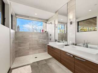 Experience modern luxury in this stunning bathroom featuring a spacious walk-in shower with a panoramic window offering breathtaking views.