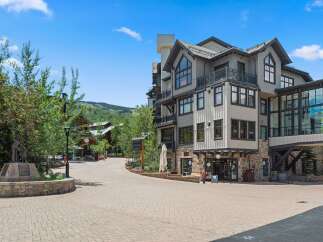 Discover luxury living in this stunning mountain resort property, featuring modern architecture with stone and wood accents.