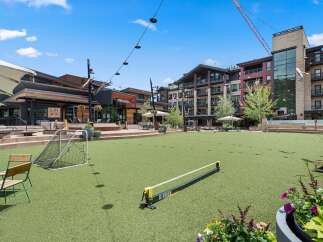 Experience outdoor living at its finest in this vibrant community space, featuring a lush green lawn perfect for recreation and relaxation.
