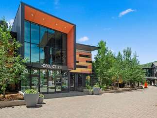 Discover modern luxury at The Collective, featuring striking architecture with vibrant orange and yellow accents.