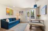 Experience comfort and style in this inviting living space, featuring a plush blue sofa perfect for relaxation.