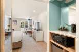 This hotel room offers a comfortable and convenient stay with a plush bed and a dining area perfect for meals or work.