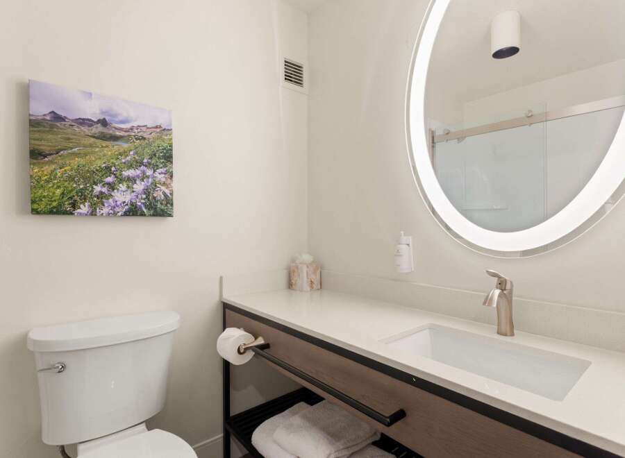 Experience comfort and style in this modern bathroom, featuring a sleek vanity with a built-in sink and a brushed nickel faucet.