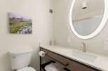 Experience comfort and style in this modern bathroom, featuring a sleek vanity with a built-in sink and a brushed nickel faucet.