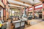 Experience the ultimate mountain lodge ambiance in this spacious lobby, featuring a grand stone fireplace and exposed wooden beams.