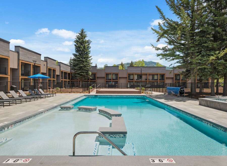 Experience luxury living with this stunning property featuring a pristine swimming pool and ample lounge seating, perfect for relaxation and entertainment.
