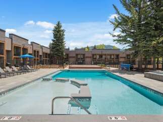 Experience luxury living with this stunning property featuring a pristine swimming pool and ample lounge seating, perfect for relaxation and entertainment.