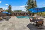 Enjoy a refreshing dip in the sparkling blue pool, surrounded by comfortable lounge chairs and shaded by vibrant blue umbrellas.