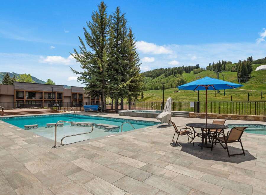 Enjoy a refreshing dip in this stunning outdoor pool area, complete with a relaxing hot tub and ample lounging space.