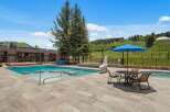 Enjoy a refreshing dip in this stunning outdoor pool area, complete with a relaxing hot tub and ample lounging space.