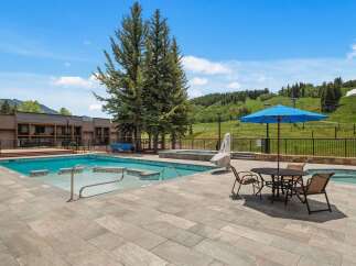 Enjoy a refreshing dip in this stunning outdoor pool area, complete with a relaxing hot tub and ample lounging space.