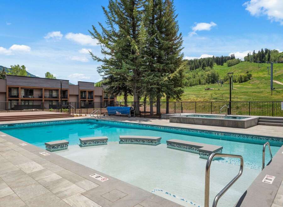 Enjoy a refreshing dip in this stunning outdoor swimming pool, complete with a relaxing hot tub and ample deck space for lounging.