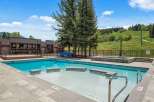 Enjoy a refreshing dip in this stunning outdoor swimming pool, complete with a relaxing hot tub and ample deck space for lounging.