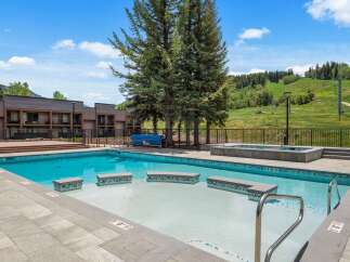 Enjoy a refreshing dip in this stunning outdoor swimming pool, complete with a relaxing hot tub and ample deck space for lounging.