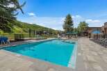 Enjoy a refreshing dip in this stunning outdoor swimming pool, complete with a relaxing hot tub and ample lounge chairs for sunbathing.